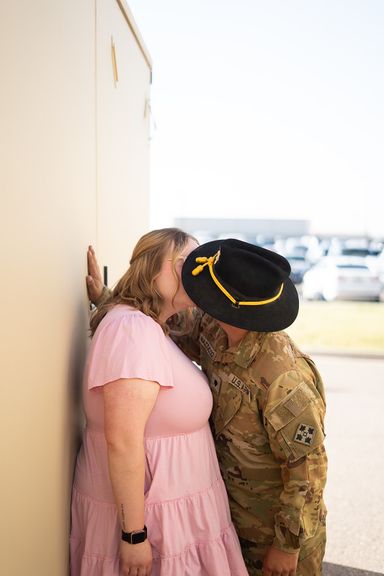 Couple sharing their first kiss after a military deployment homecoming