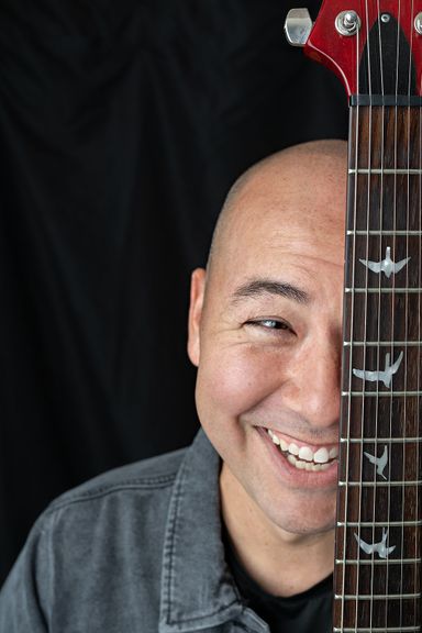 Smiling male musician posing with a guitar for personal branding photography