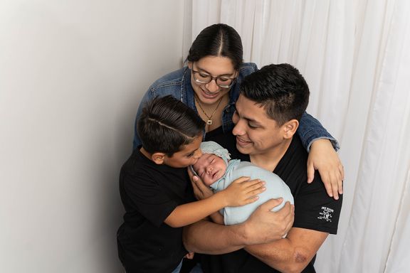 family loving on their new baby 