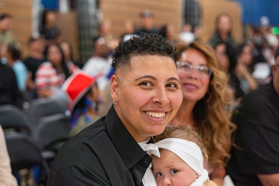 Parent holding their baby during a military homecoming celebration