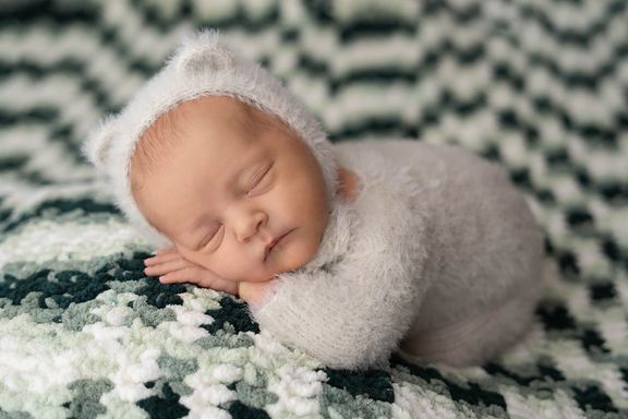 Newborn baby sleeping on textured backdrop 