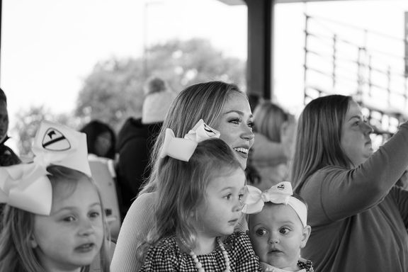 Mother and children waiting for their loved one during a military homecoming