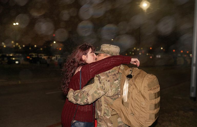 Emotional military homecoming reunion as a couple embraces after deployment