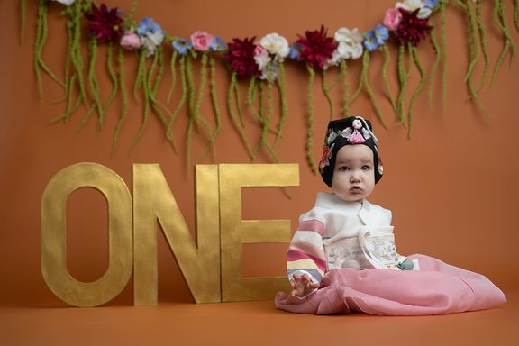 Baby girl celebrating her first birthday during a studio milestone photography session