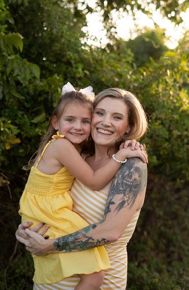 Mother and daughter hugging during a relaxed outdoor family portrait session