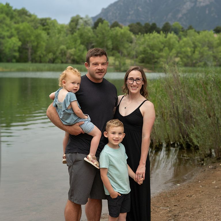 Family of four photographed together outdoors by the water in Colorado Springs