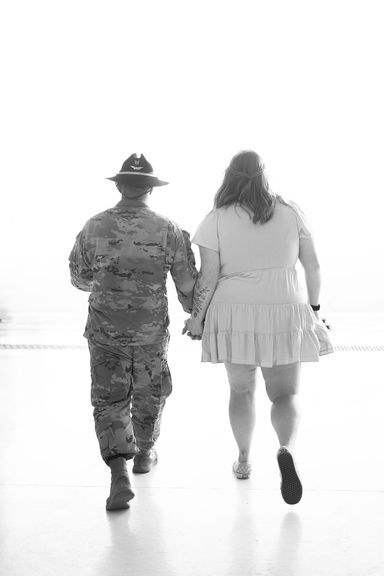 Service member walking hand in hand with a loved one after returning home