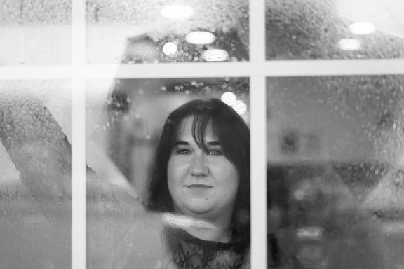 Black and white creative portrait of a woman photographed through a window