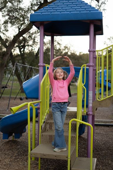 Young girl playing at a playground during an outdoor personality portrait session