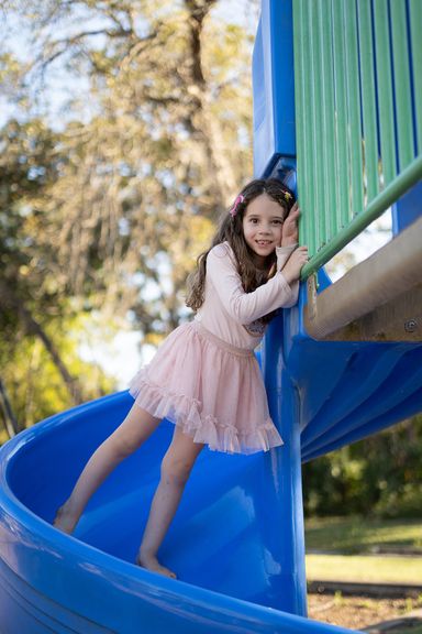 Young girl playing on a playground during an outdoor childhood photography session