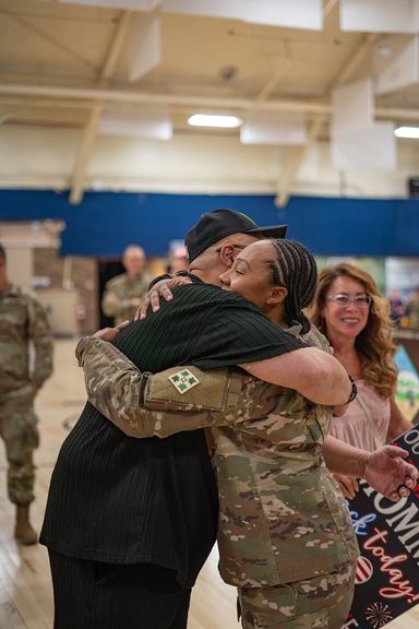 Emotional embrace between loved ones during a military homecoming