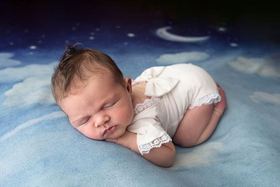 Newborn baby laying on moon backdrop