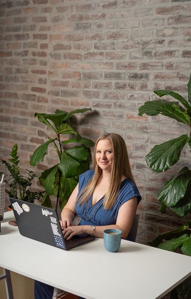 Female business owner working on a laptop during a Colorado Springs branding session