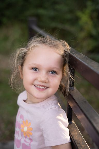 Young girl smiling outdoors during a natural childhood portrait session